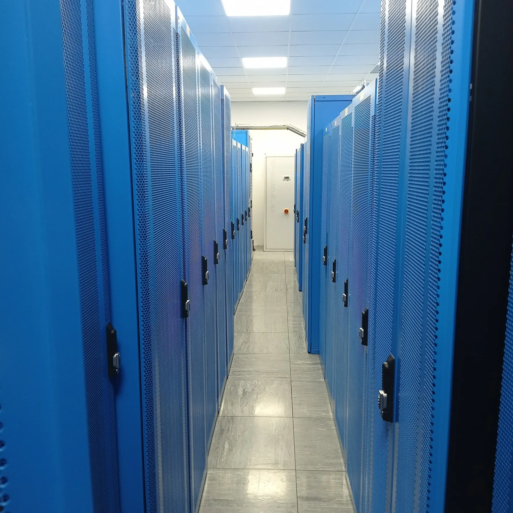 Blue server cabinets lining a data-centre aisle